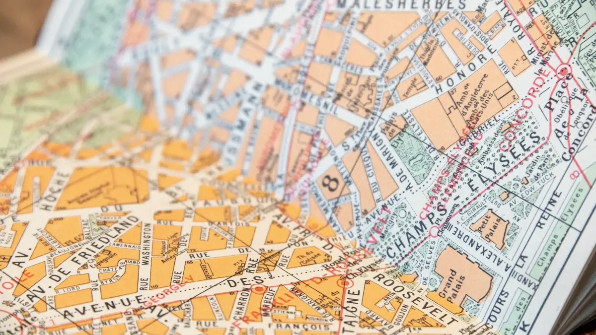 Un plan de ville imprimé, ses avenues et ses pâtés de maisons en aplats de couleur.